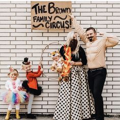 two adults and three children standing in front of a brick wall with a sign that says the brown family circus