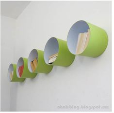 a row of green cups hanging on the side of a wall next to a white wall