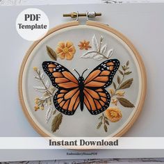 an orange butterfly with white wings and yellow flowers is featured in this hand embroidery pattern