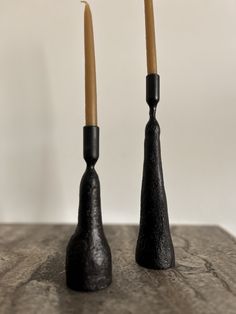 two black candlesticks sitting on top of a table