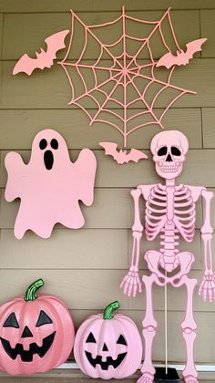 halloween decorations on the front porch with pink and orange pumpkins, jack - o'- lanterns, and spider web