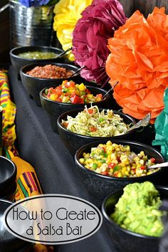 bowls filled with food sitting on top of a table covered in tissue paper pom poms