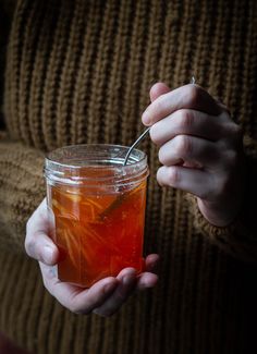 a person holding a jar filled with liquid