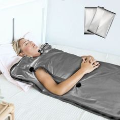 a woman laying on top of a bed in a room with white walls and pillows