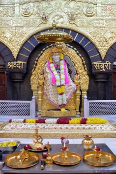 an idol is displayed in the middle of a room filled with gold and white decorations