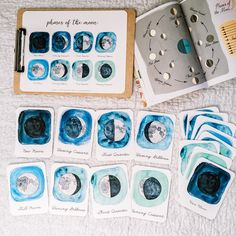 the phases of the moon are shown in blue and white paper on a bed with a notebook