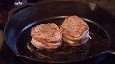 two meat patties are cooking in a frying pan