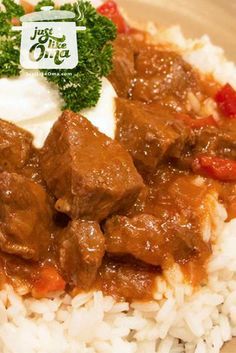 a close up of a plate of food with rice and meat on it's side