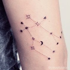 a woman's arm with stars and moon tattoos on it