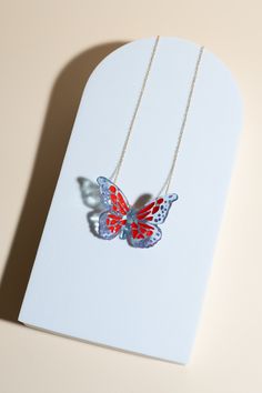 Based in: USAThis captivating piece is not just jewelry; it's a statement of individuality and elegance.Imagine a delicate butterfly, seemingly suspended in mid-flight, its wings adorned with mesmerizing red specks and intricate purple details. Each detail is meticulously crafted to capture the essence of grace and allure. This necklace is more than just an accessory; it's a reflection of your unique style and appreciation for sustainable craftsmanship. Wear it proudly to elevate any outfit, whether it's a casual ensemble or formal attire, and let it be a conversation starter wherever you go. Make a statement with this one-of-a-kind necklace! Details Made in: Broward, Florida Dimensions: 1.5" in. x 2" in. Chain length: 18" Weight: 0.1 oz. Metal: gold-plated chain Material: soy-based resin Butterfly Charm Necklace For Party, Red Butterfly-shaped Jewelry Gift, Red Butterfly Jewelry For Gift, Red Butterfly Necklace For Gift, Red Butterfly Charm Necklace, Multicolor Butterfly Print Jewelry Gift, 3d Technology, Delicate Butterfly, Purple Details