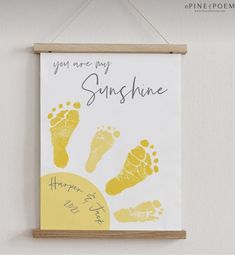 a hand and foot print hangs on the wall next to a sign that says, you are my sunshine