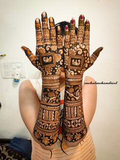 a woman is holding her hands up with hendi designs on it