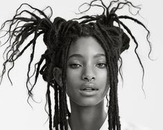 a black and white photo of a woman with dreadlocks