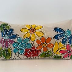 a decorative pillow with flowers painted on it