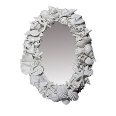 a mirror that has shells on it and is white with a black border around the edge