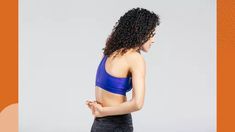 a woman with curly hair wearing a blue sports bra