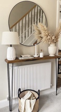 a mirror sitting above a radiator next to a table with a basket on it