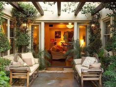 an outdoor living area with couches and potted plants