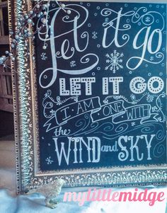 a chalkboard sign that reads let it go, let it go the wind and sky