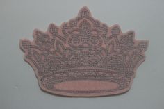 a pink embroidered crown on a white background