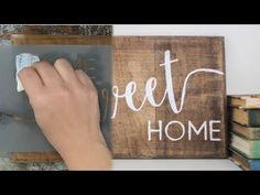 someone is using a chalkboard to write the words home on wood and paint it white