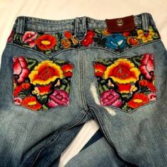 a pair of jeans with flowers painted on them