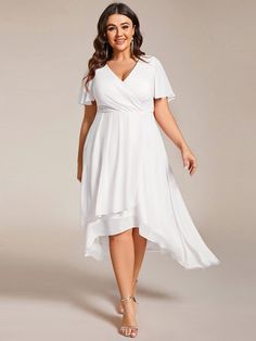 a woman wearing a white dress with short sleeves and an asymmetrical neckline