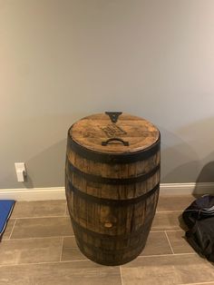 a wooden barrel sitting on top of a tile floor