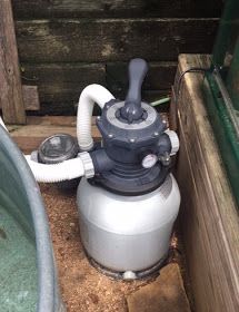 a water filtrator sitting in the corner of a wooden building next to a tub