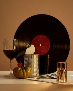 an old record, wine glass and other items on a table