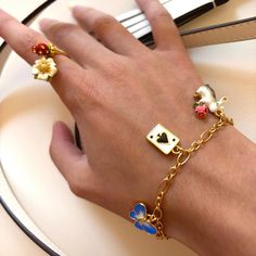 Unlock the secret of timeless style with Secret Garden Rabbit Bracelet. Meticulously crafted with an elegant poker charm and subtly lustrous enamel, this exquisite adornment is the epitome of tasteful luxury. A heartfelt addition to any jewelry collection. DETAILS Plating: 18K Gold Materials: 18K Gold on Brass, Enamel Size:  8.03 "/20.4cm Weight:  10.1g Hypoallergenic design Whimsical Metal Jewelry With Vintage Charm, Whimsical Vintage Charm Jewelry, Whimsical Gold Jewelry With Flower Charm, Enamel Charms Bracelet, Luxury Dangling Charms Jewelry For Gifts, Luxury Dangling Charms Jewelry Gift, Luxury Jewelry With Dangling Charms For Gifts, Elegant Enamel Dangle Jewelry, Yellow Gold Enamel Jewelry With Flower Charm