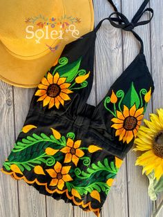 This Beautiful Sunflower Embroidered Halter Top is the perfect Top for Everyday use or a special event. It is comfortable, with elastic on the back and has a tie around the neck for an adjustable fit. This blouse comes in one size which fits sizes Small and Medium. Green Embroidered Top For Summer, Summer Embroidered Top With Floral Print, Multicolor Embroidered Floral Top For Summer, Multicolor Embroidered Floral Print Top For Summer, Fitted Floral Embroidered Top For Festival, Fitted Floral Embroidered Top For Summer, Fitted Floral Print Embroidered Top For Summer, Intricate Embroidery Summer Festival Top, Beach Fitted Embroidered Top