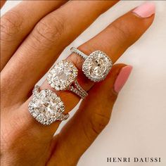 a woman's hand with three diamond rings on it