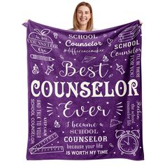 a woman holding up a purple blanket with the words best counselor ever written on it