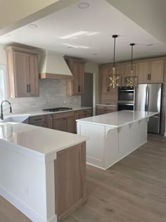 an empty kitchen with wooden cabinets and white counter tops, along with stainless steel appliances