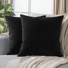 two black pillows sitting on top of a couch