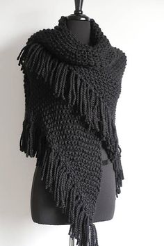 a black knitted shawl on a mannequin