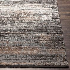 an area rug with various colors and patterns on the floor, including brown, gray, beige