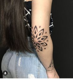 a woman's arm with a tattoo design on the left side of her arm