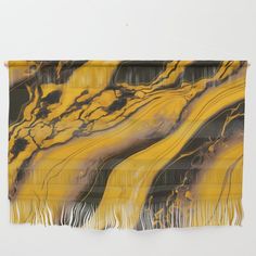 a yellow and black wall hanging with fringes