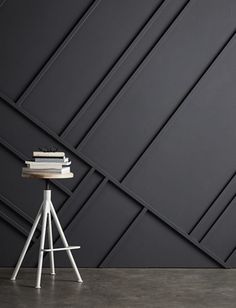 a white chair sitting in front of a black wall