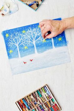 someone is painting trees in the snow with crayons and watercolor pencils