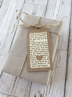 a gift wrapped in brown paper and tied with twine on top of a wooden table