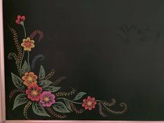 a chalkboard with flowers painted on it in front of a black background and pink trim