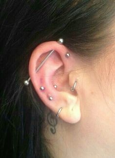 a woman's ear has three piercings on it