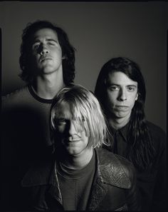 the band nirvana posing for a black and white photo with one man looking at the camera