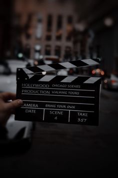 a person holding up a movie clapper on the street