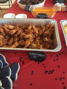 several trays of food sitting on top of a red table cloth covered tablecloth