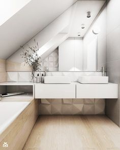 a bathroom with two sinks and a bathtub under a slanted roof above it