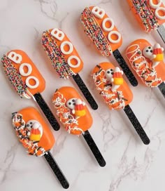 an assortment of halloween candy lollipops with frosting and sprinkles